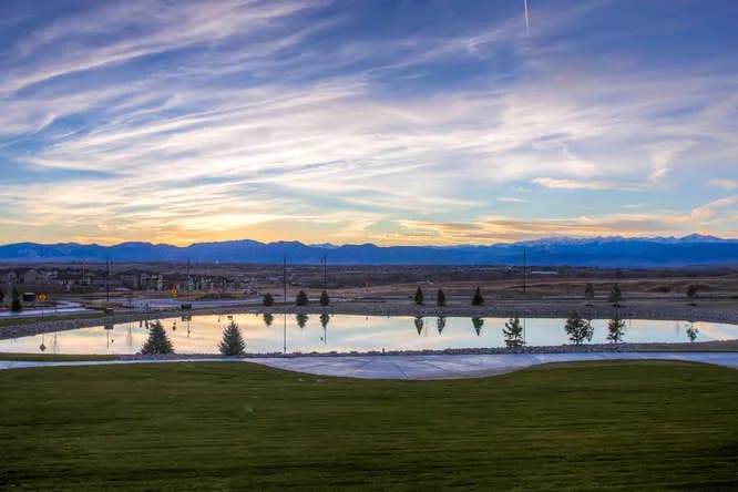 A Front Range community at sunset with a water feature