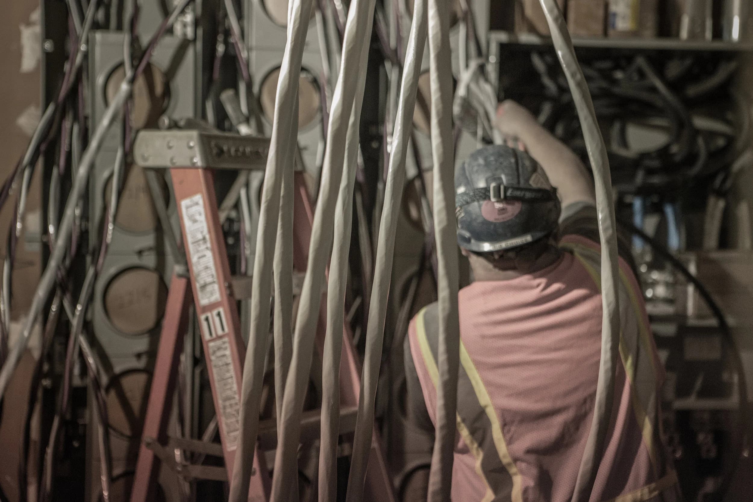 Courtesy Electric worker handling a large wire bundle