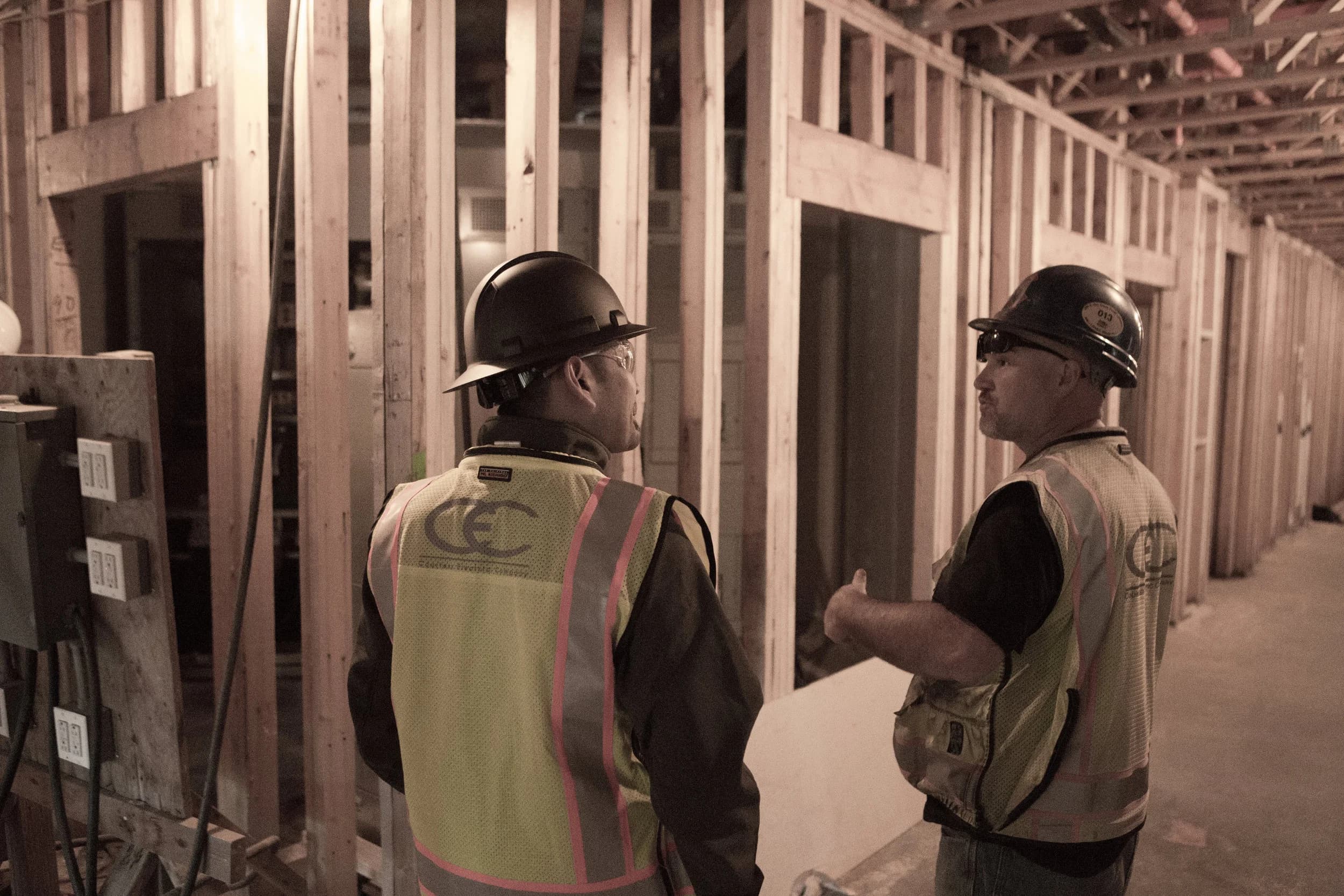 Courtesy Electric foremen reviewing a framed interior