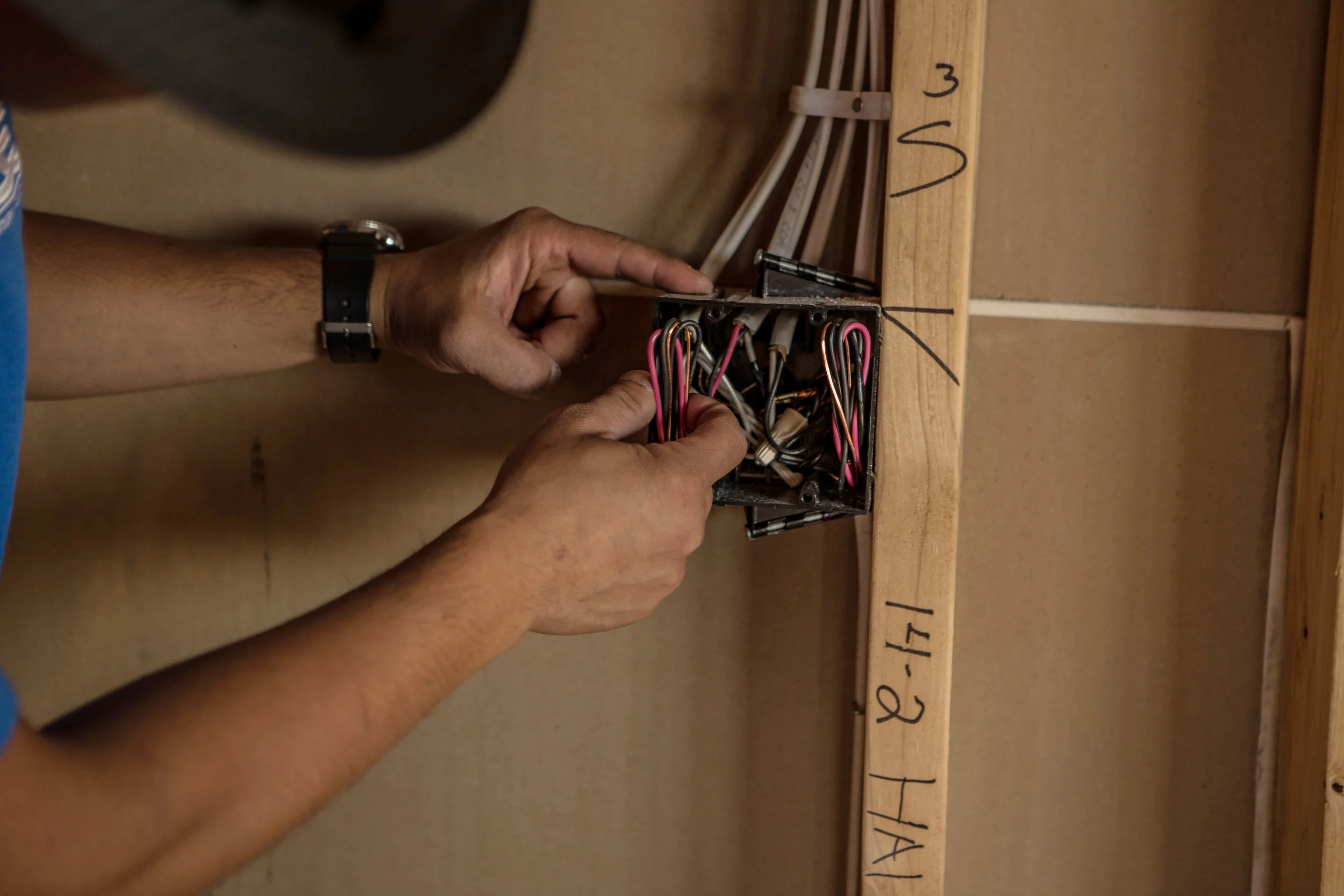 Hands terminating a low-voltage panel